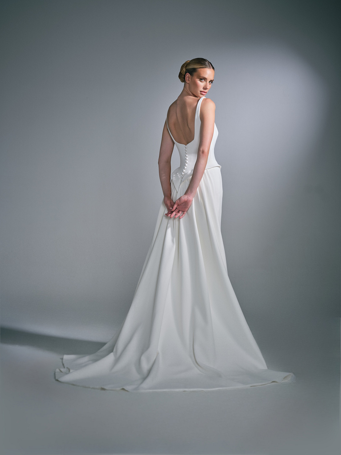 Back view of the Celiane bridal dress, showing the covered buttons and sweeping skirt train.