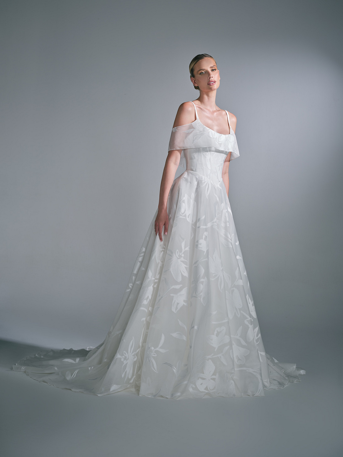 Full-length front view of the Liora wedding dress by Suzanne Neville, showcasing a sculpted bodice and modern bridal silhouette and an organza detachable collar
