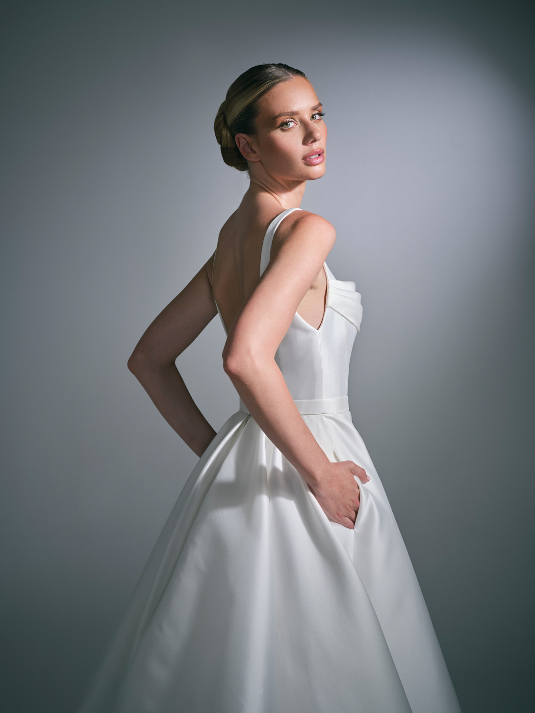The Lysenne Bridal Gown by Suzanne Neville has a low scoop back is finished with covered buttons, while the sweeping train completes the silhouette.